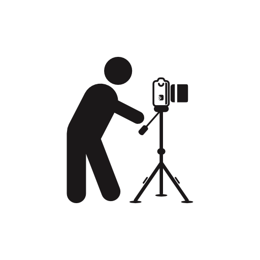 Photographer Standing Behind Photo Camera On A Tripod From Side
