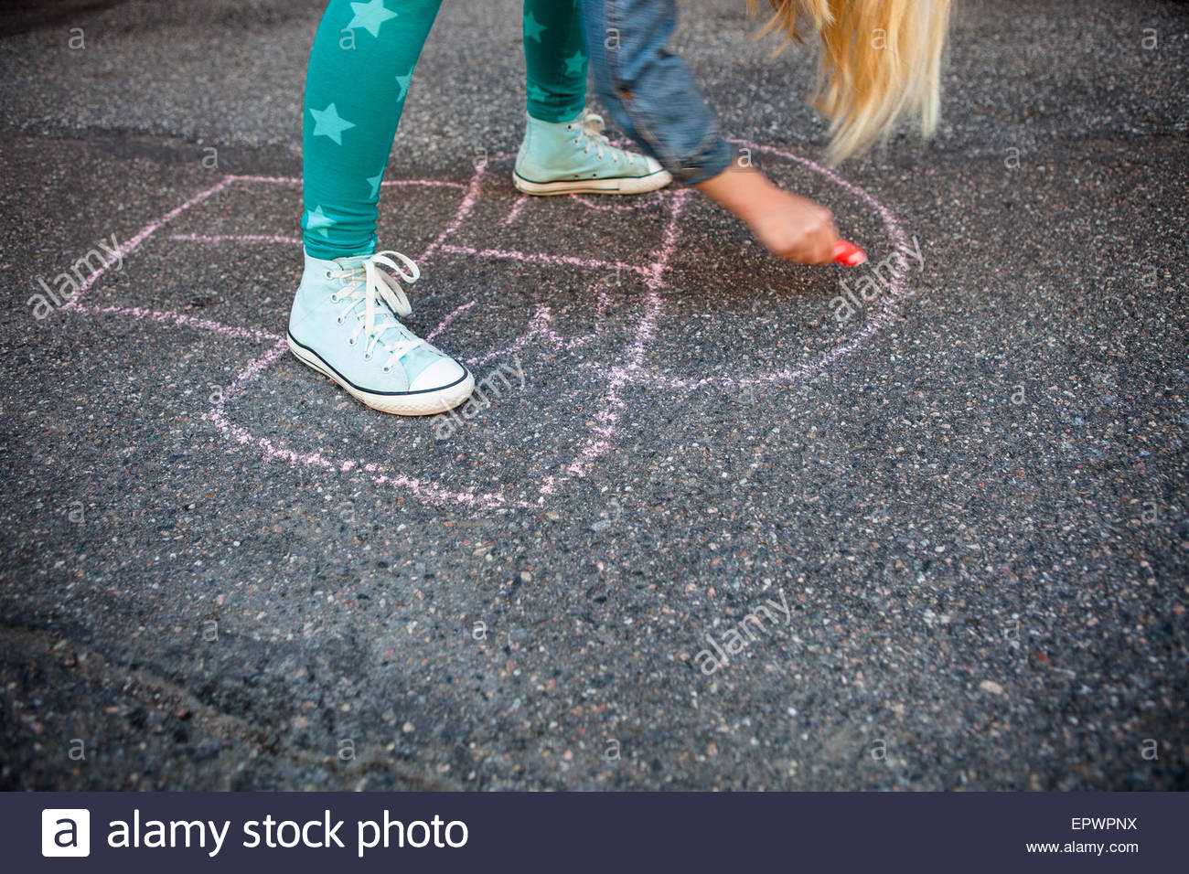 1300x956 Girl Drawing A Hopscotch On Asphalt With Street Chalk Stock Photo