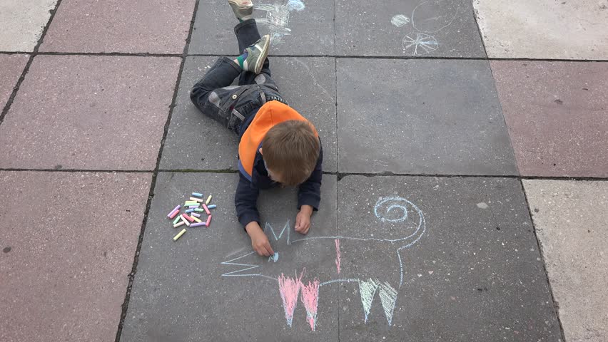 852x480 Happy Child Laying Down On Asphalt Drawing With Colored Chalk