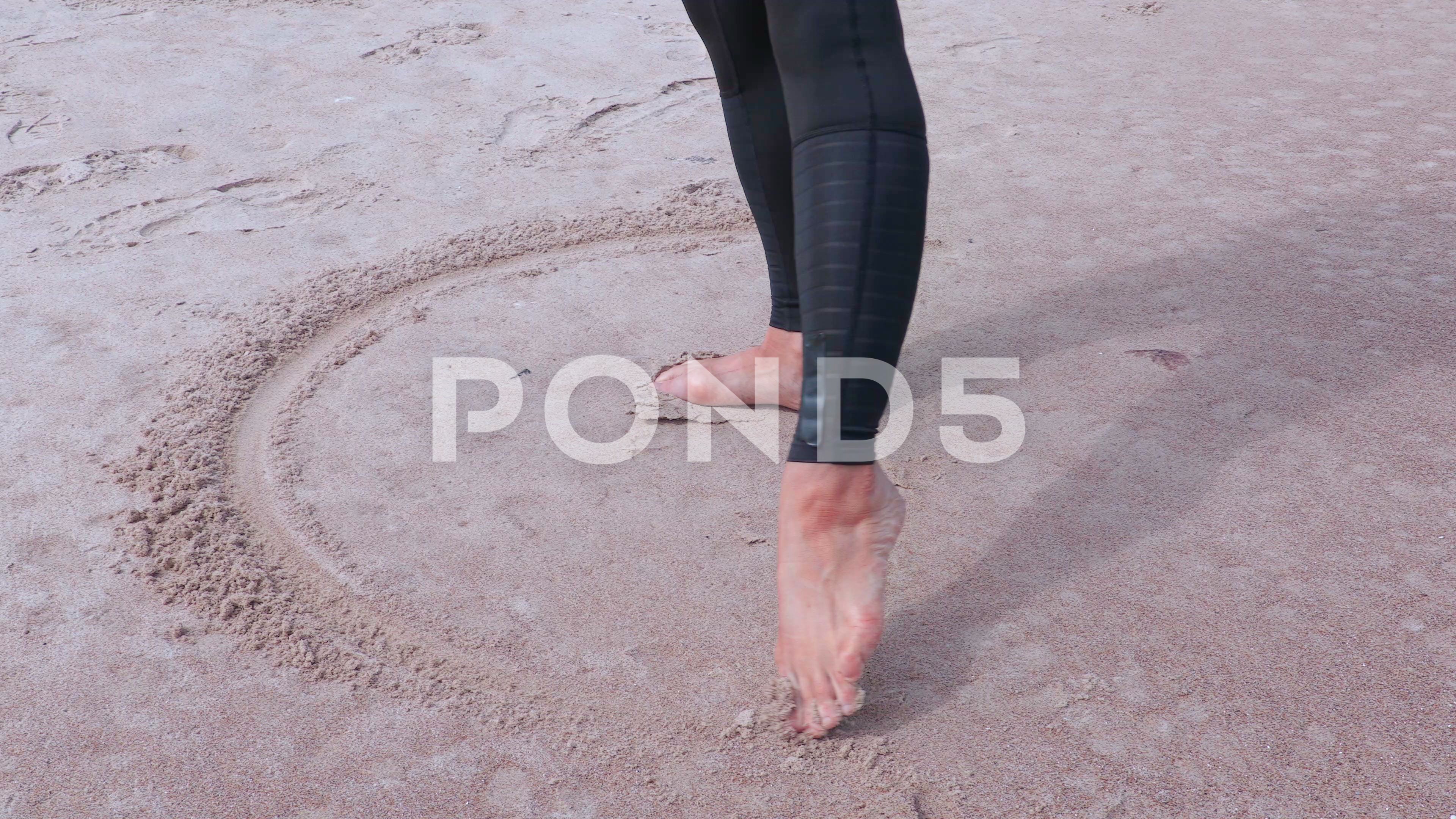 3840x2160 Woman With Bare Feet Drawing Circle On Sand Near Sea ~ Footage