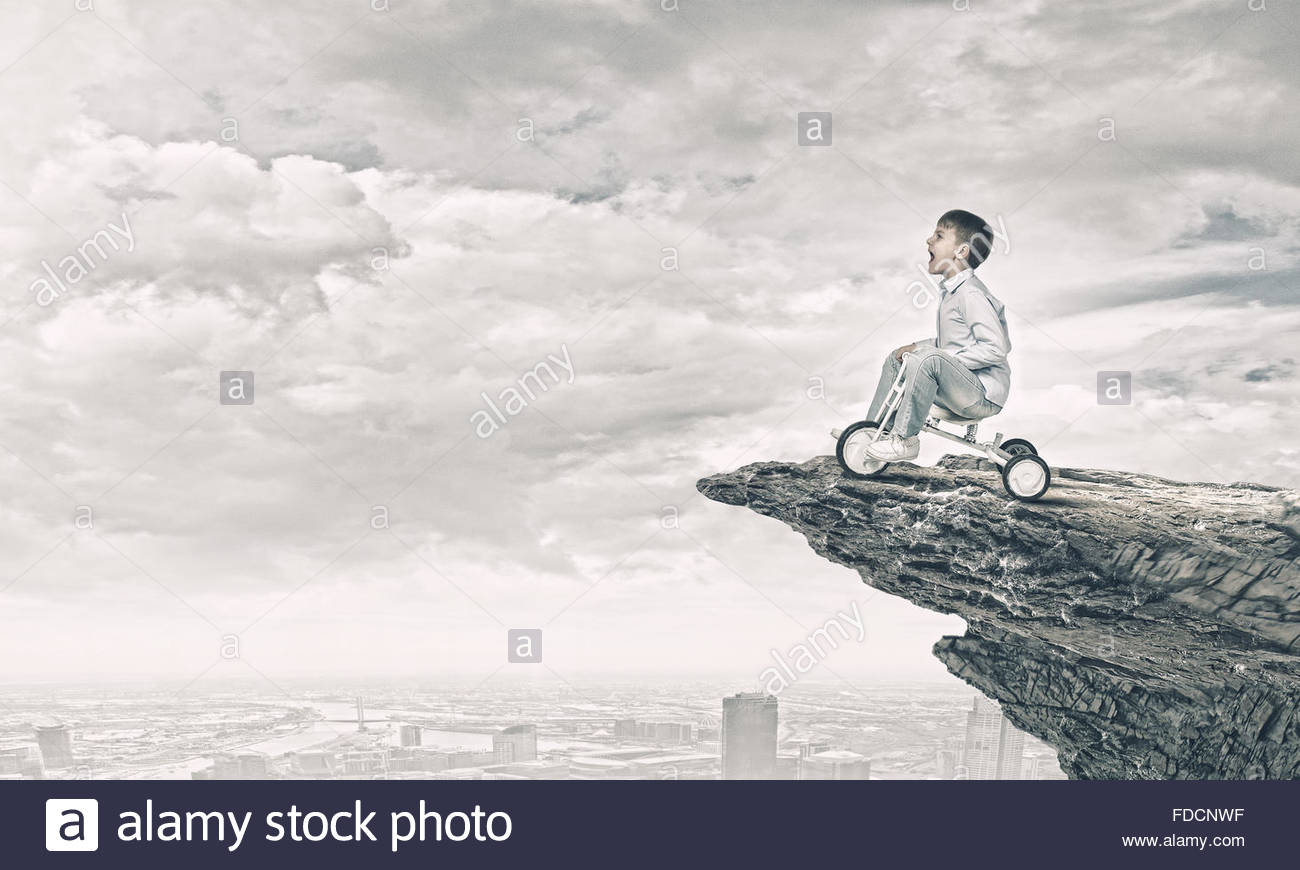 1300x870 Little Joyful Cute Boy Riding Tricycle On Cliff Edge Stock Photo