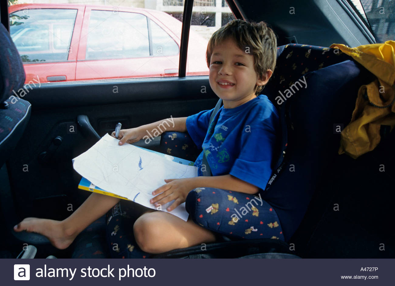 1300x940 Young Boy Drawing In The Back Seat Of A Car, Spain Stock Photo