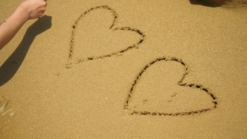 852x480 Girl On A Beach Draws A Hearts On Sand. Girl Drawing Heart Symbol
