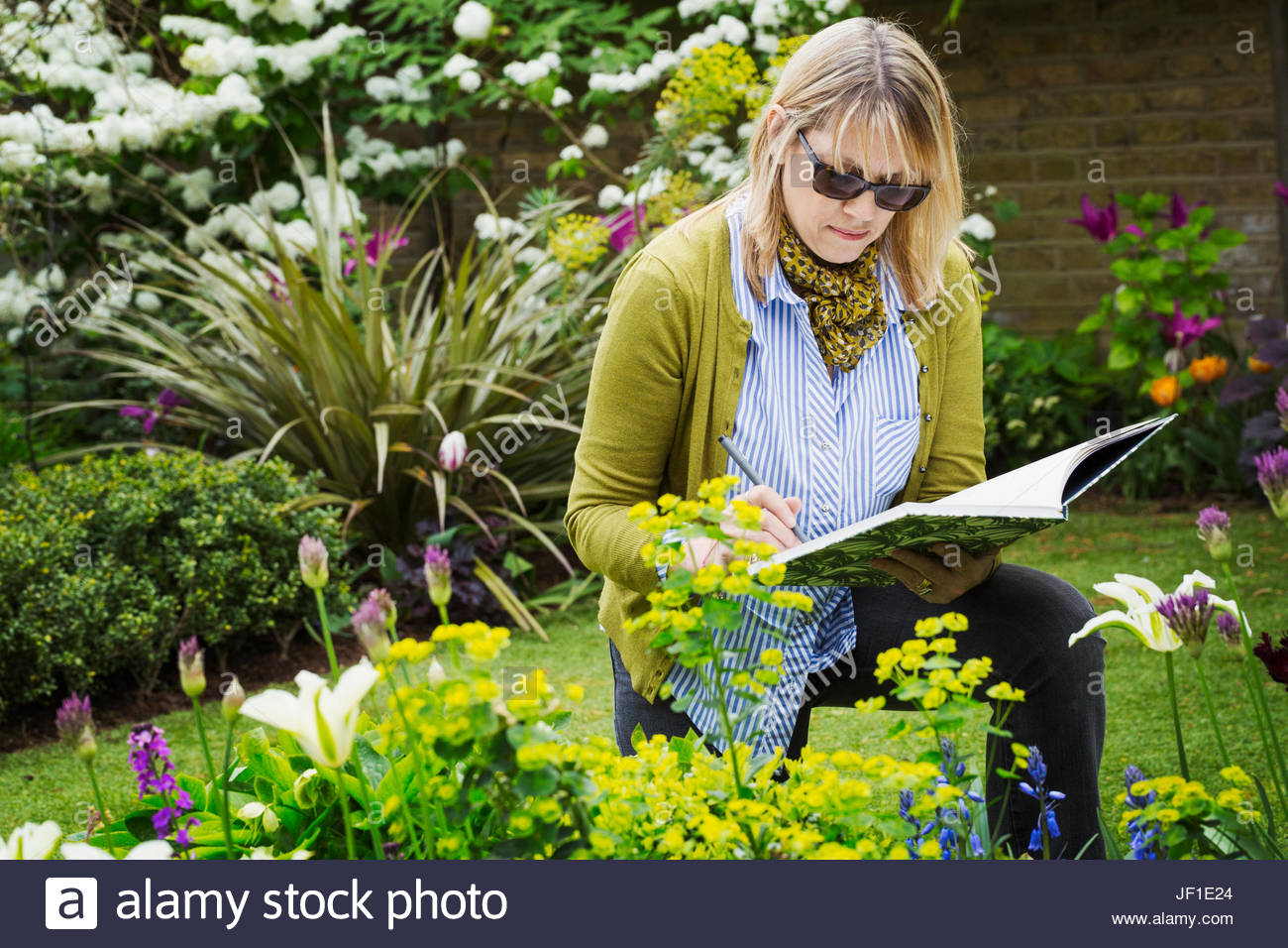 1300x956 Woman Wearing Sunglasses Standing In A Garden By A Flowerbed