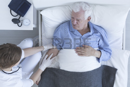 450x300 Shot Of Nurse Drawing Blood Of Senior Patient Lying On