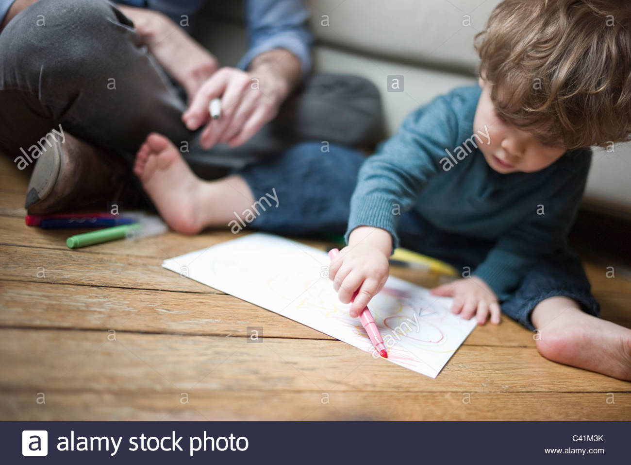 1300x957 Toddler Boy Sitting On Floor With Parent, Drawing On Paper Stock
