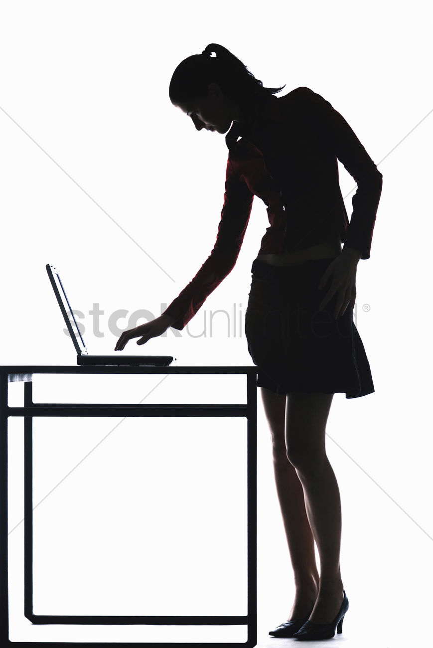 869x1300 Silhouette Of Businesswoman Using Laptop Stock Photo