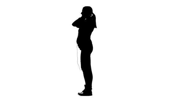 590x332 Pregnant Through The Headphones Listening To Music. Silhouette