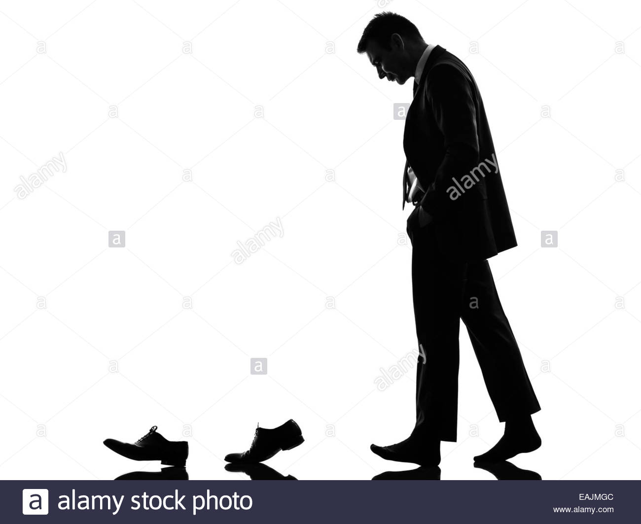 1300x1063 One Caucasian Business Man Walking Behind His Shoes In Silhouette