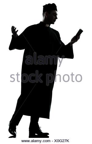 300x469 One Caucasian Man Priest Reading Bible Silhouette In Studio