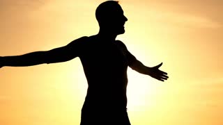 320x180 Silhouette Of Happy Man Turning Around On The Beach During Sunset