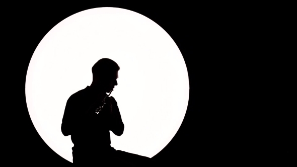 590x332 Silhouette Of A Guy Musician. A Young Man Plays The Flute While