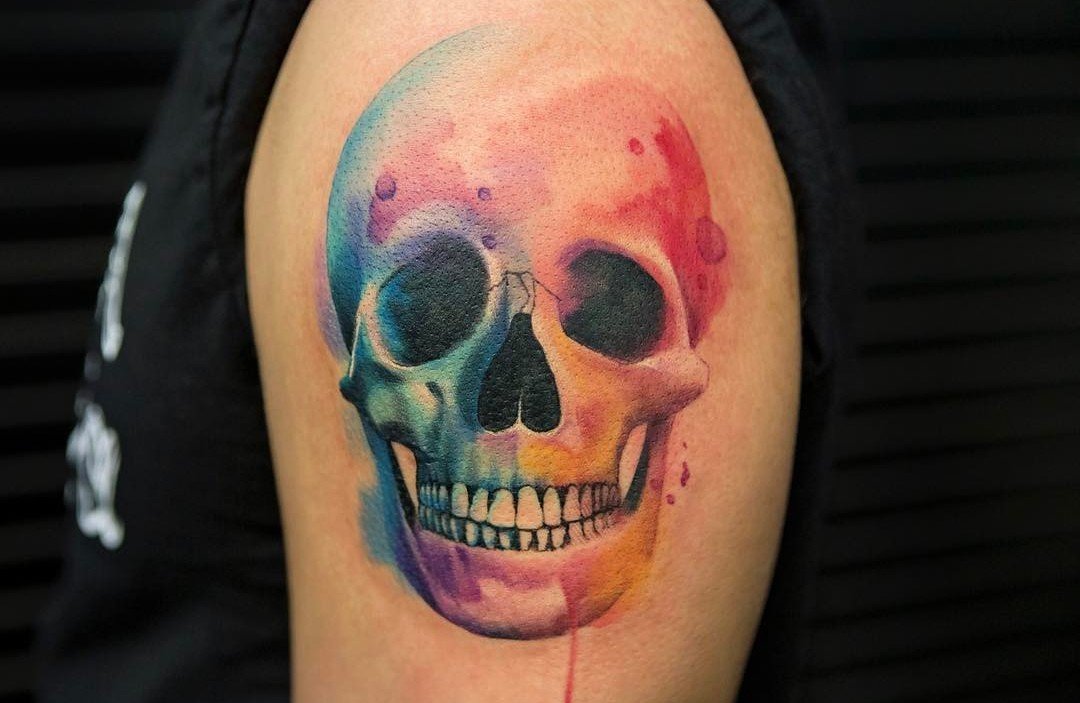 1080x703 Colorful Watercolor Skull Tattoo On Upper Arm